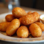 Deliciosas croquetas de jamón recién fritas, crujientes por fuera y cremosas por dentro.